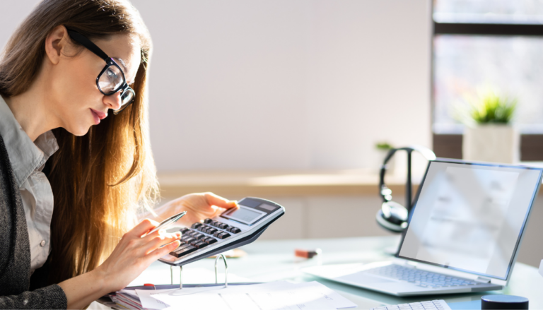 personne qui gère sa comptabilité avec ordinateur et calculatrice