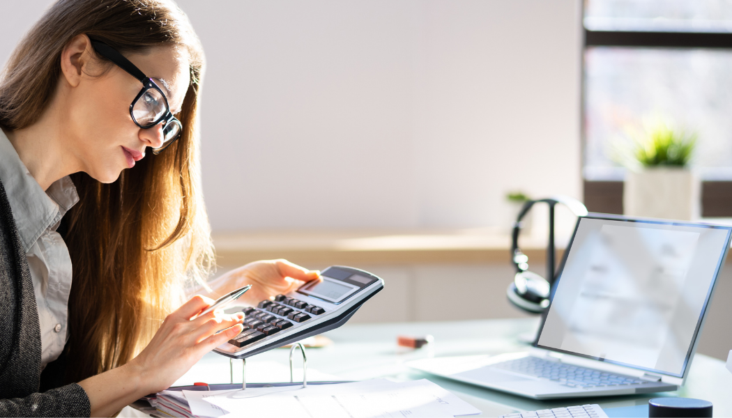 personne qui gère sa comptabilité avec ordinateur et calculatrice